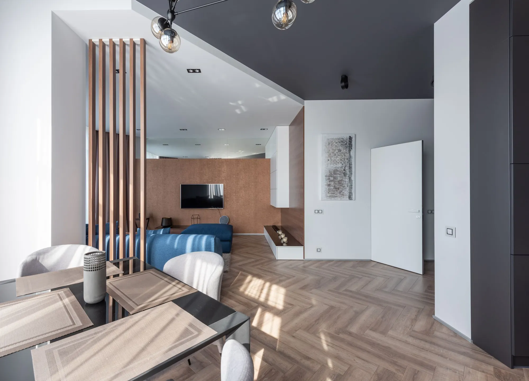 Modern interieur met visgraatvloer, eettafel en grote ramen