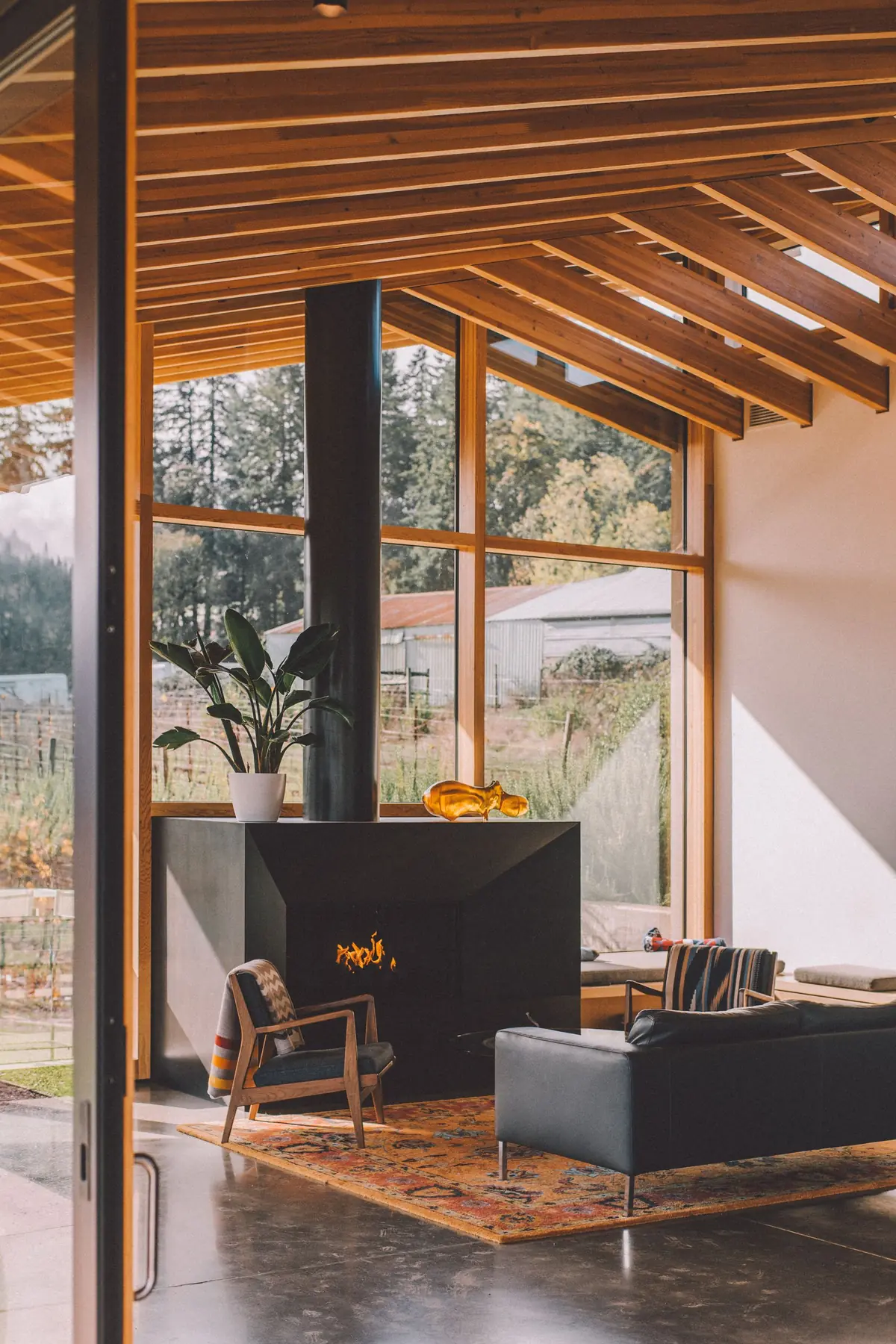 Zonnige woonkamer met grote houten kozijnen, haard en houtlook vloer